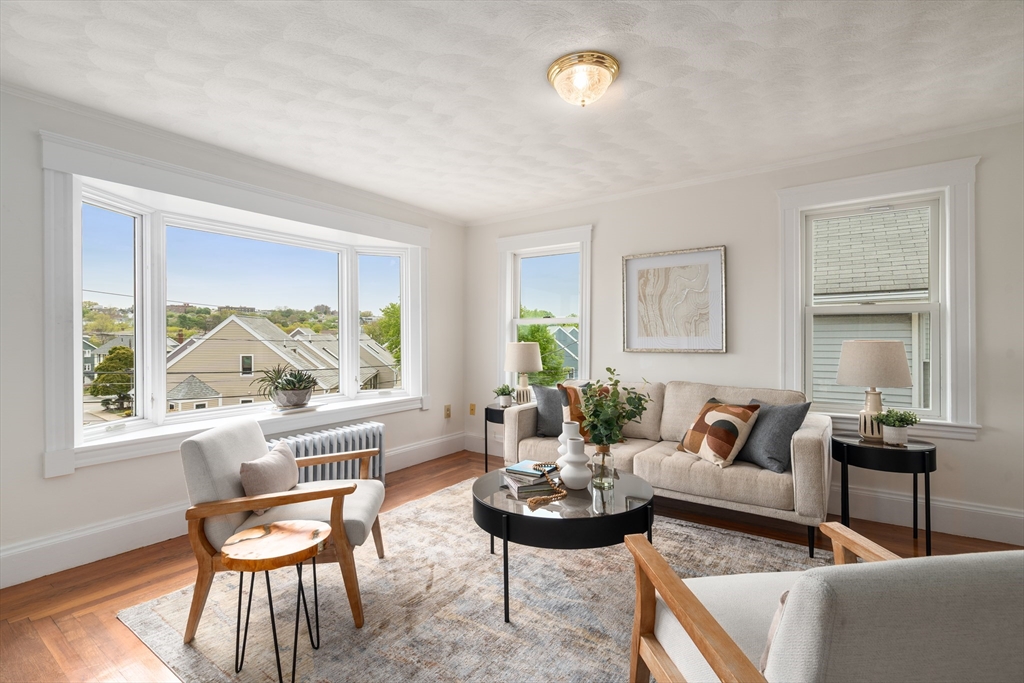93 Puritan Road, Unit 93 Somerville, MA 02145 - Photo 2 of 20 a living room with furniture and a large window