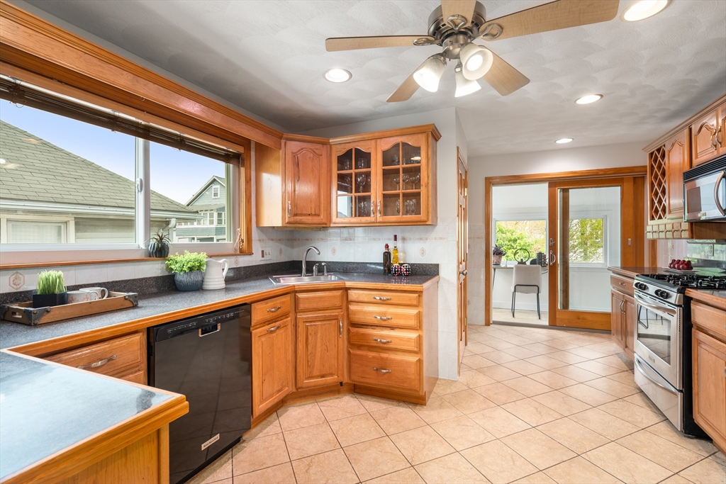 93 Puritan Road, Unit 93 Somerville, MA 02145 - Photo 7 of 20 a kitchen with stainless steel appliances granite countertop a sink and a stove
