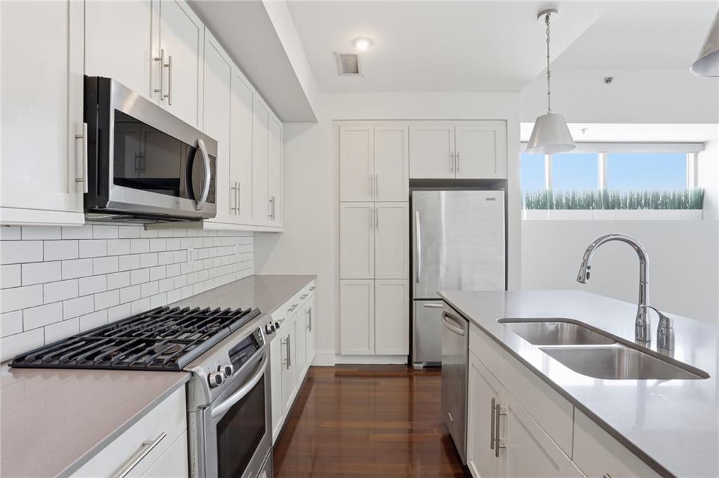 1100 Howell Mill Road Northwest, Unit 608 Atlanta, GA 30318 - Photo 4 of 37 a kitchen with stainless steel appliances granite countertop a sink dishwasher a refrigerator and a microwave