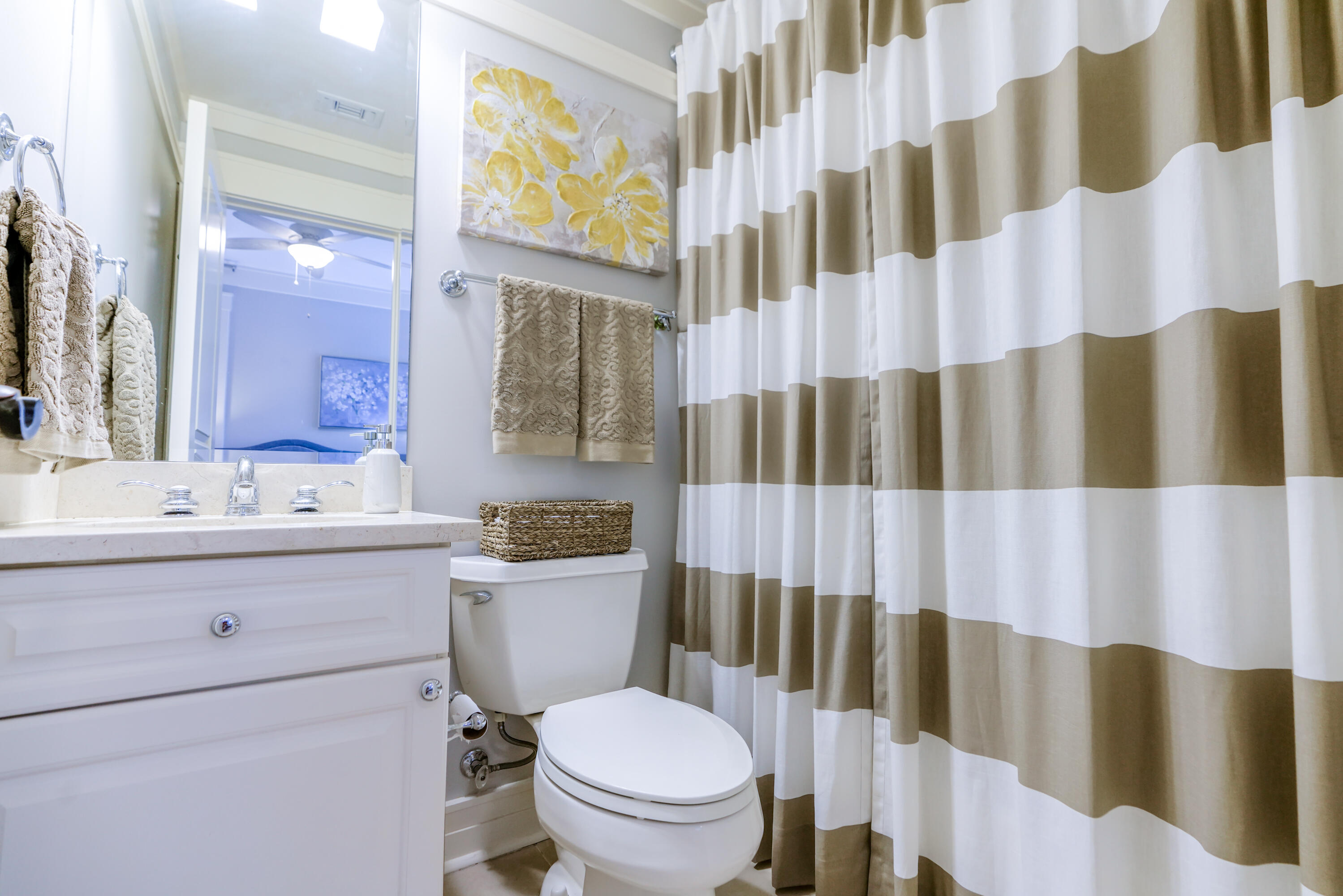 1101 Prospect Promenade, Unit 101 Panama City Beach, FL 32413 - Photo 23 of 49 a bathroom with a sink a toilet and shower curtain
