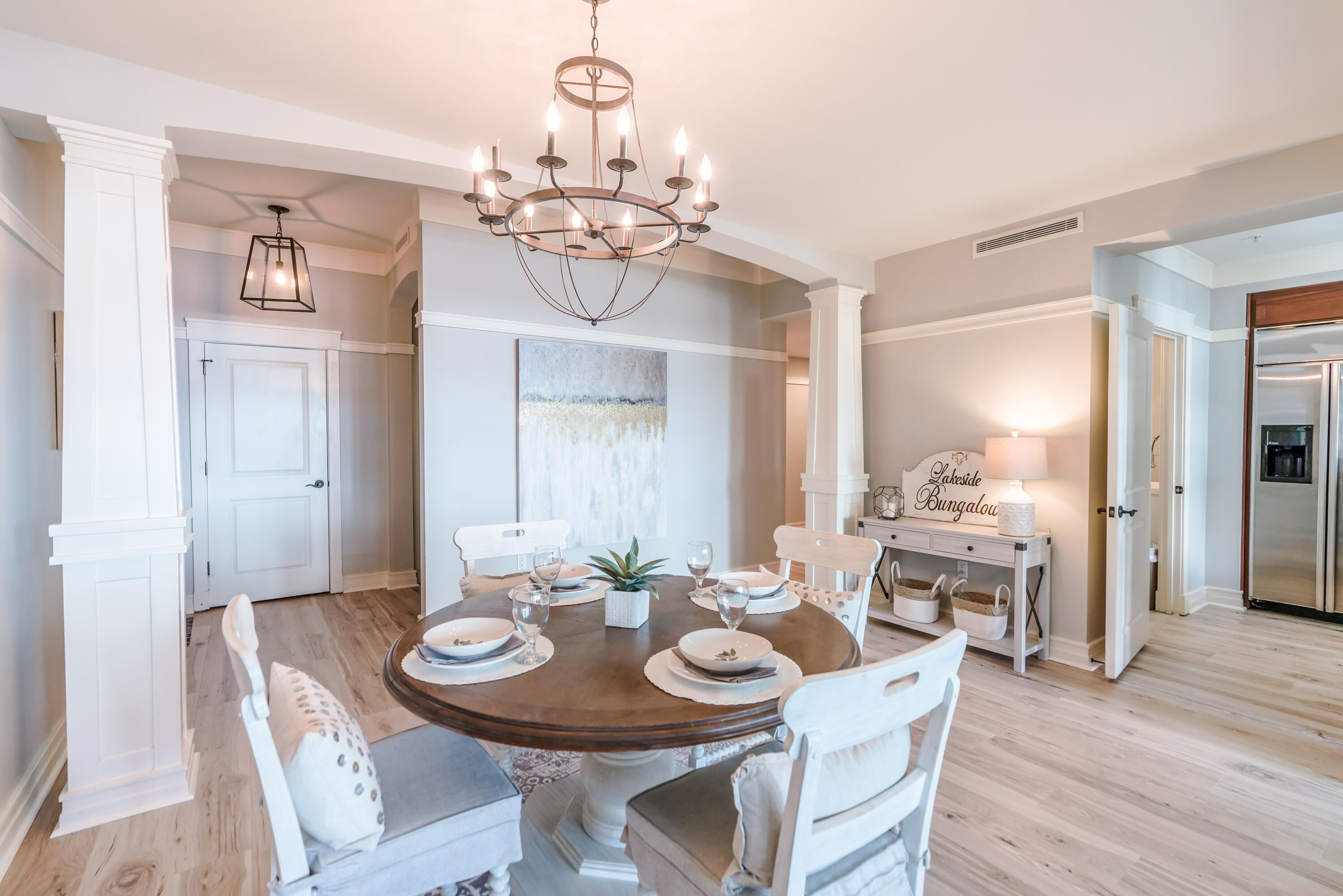 1101 Prospect Promenade, Unit 101 Panama City Beach, FL 32413 - Photo 5 of 49 a view of a dining room with furniture wooden floor and chandelier
