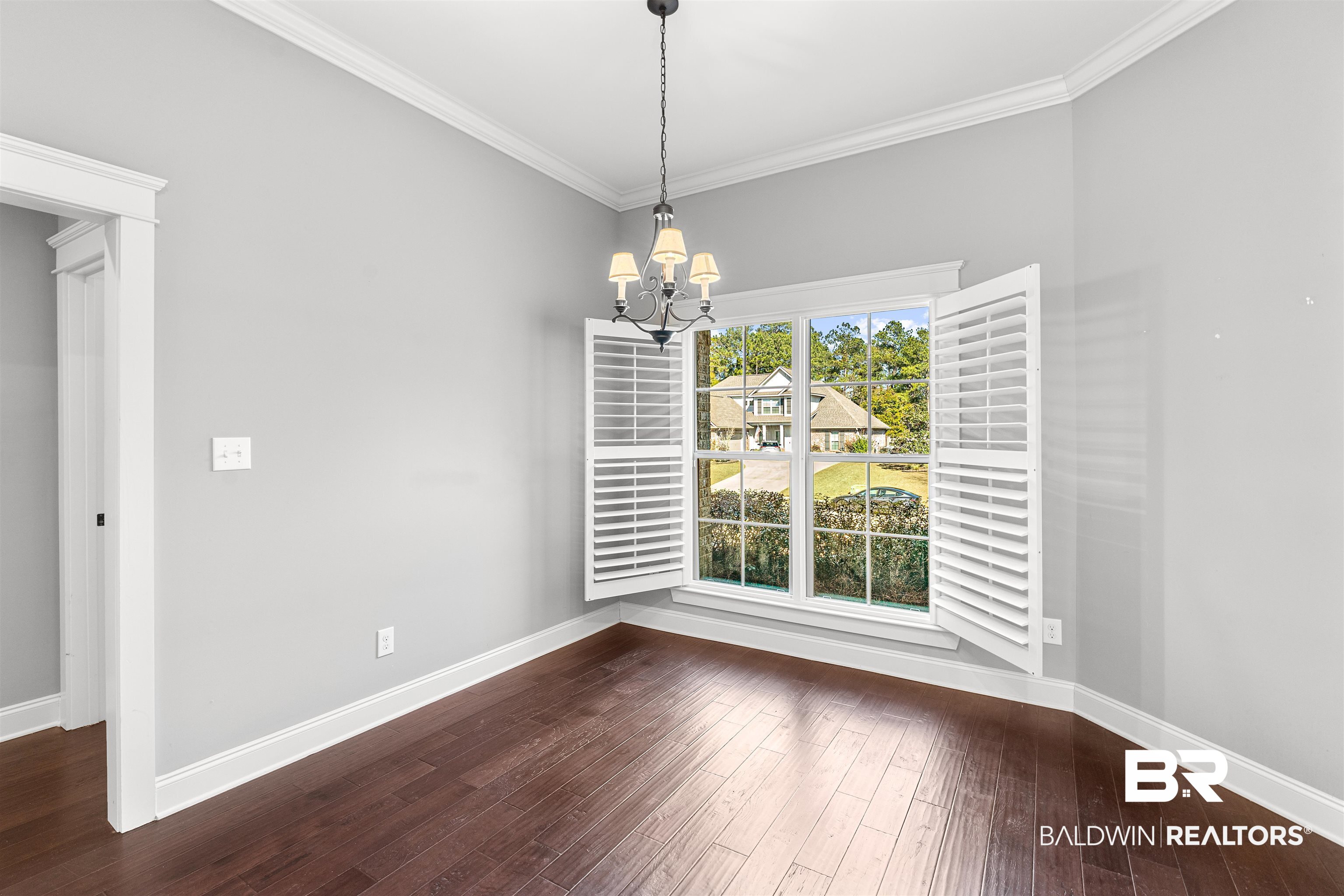 8844 Rosedown Lane Daphne, AL 36526 - Photo 7 of 24 Unfurnished dining area with ornamental molding, suspended lighting, and dark wood-type flooring
