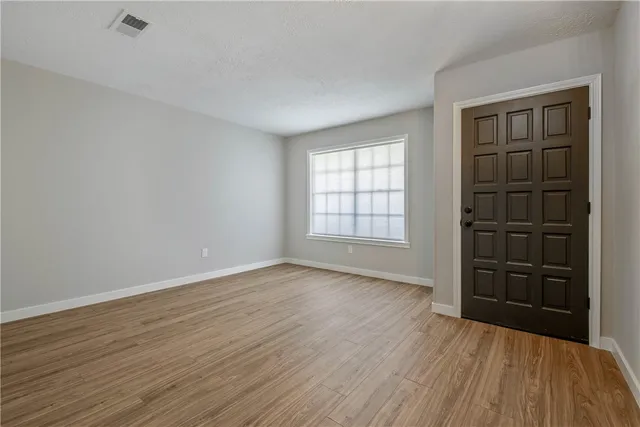 wooden floor in an empty room with a window