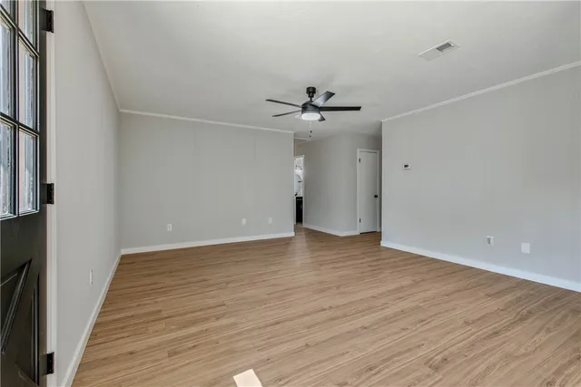 a view of an empty room with wooden floor