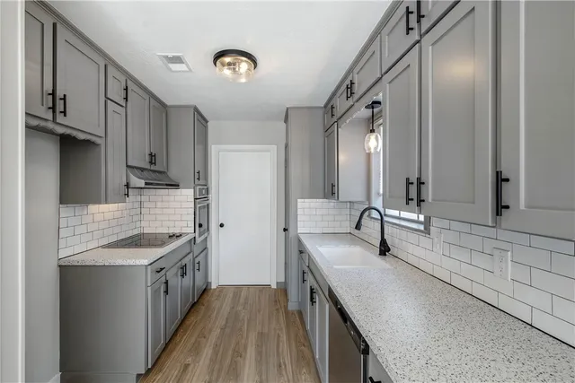 a kitchen with stainless steel appliances granite countertop a sink stove and cabinets