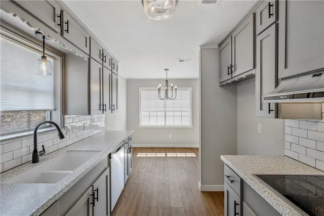 a kitchen with stainless steel appliances granite countertop a sink stove and cabinets