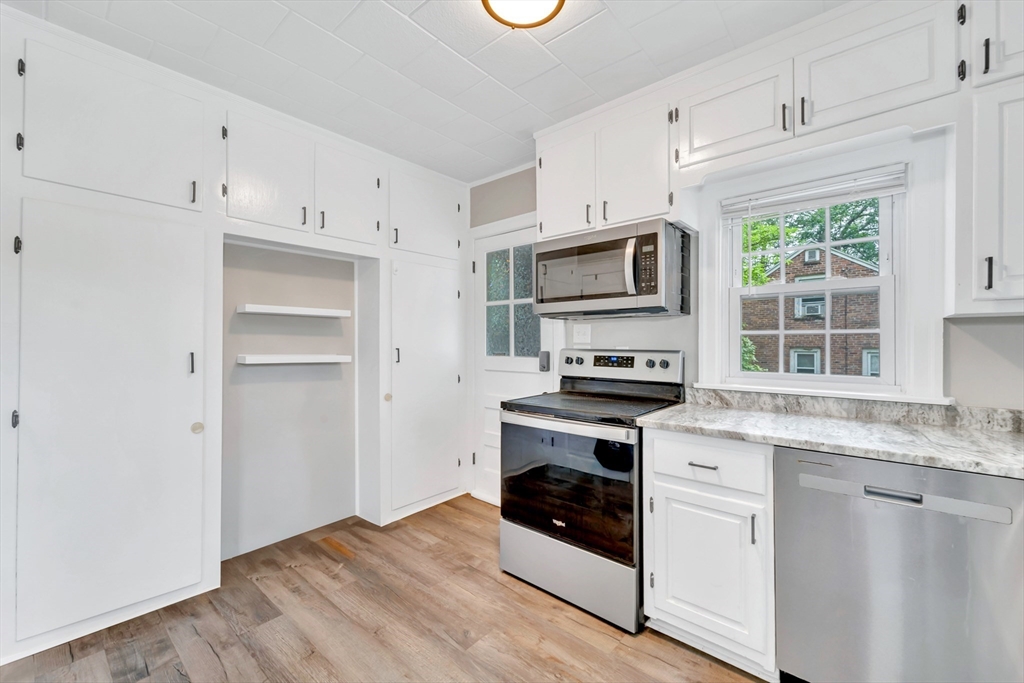 295 Harkness Avenue Springfield, MA 01118 - Photo 6 of 39 a kitchen with granite countertop a stove a sink and a refrigerator