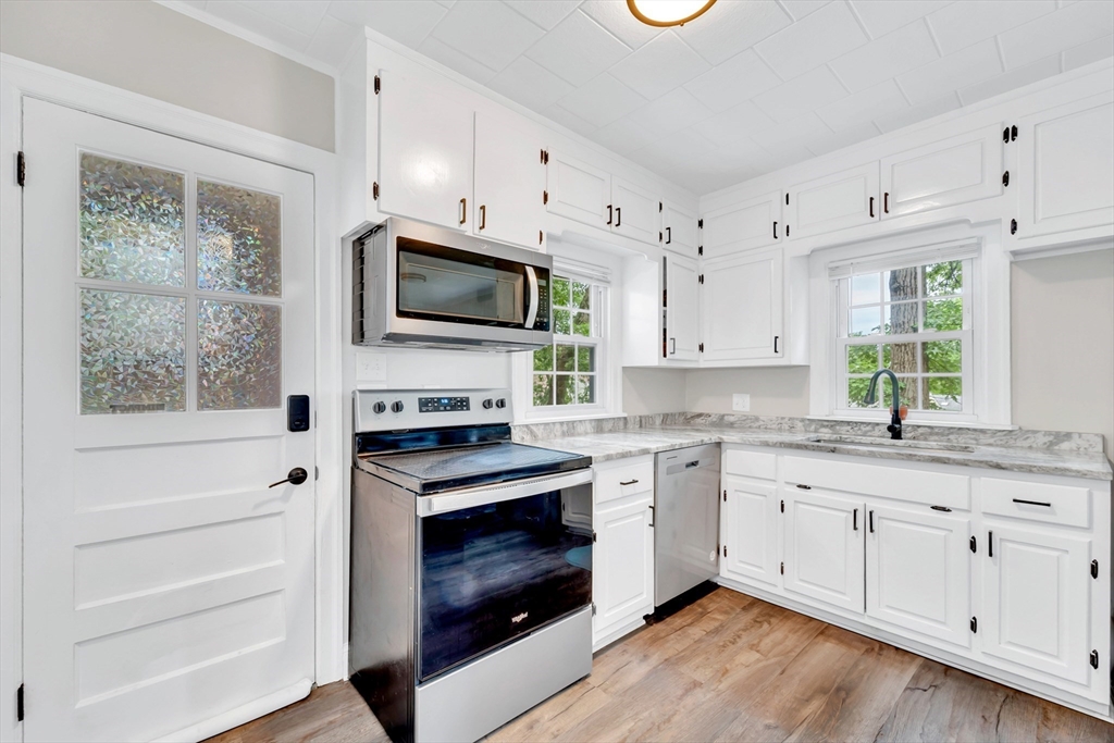 295 Harkness Avenue Springfield, MA 01118 - Photo 8 of 39 a kitchen with cabinets stainless steel appliances a sink and wooden floor