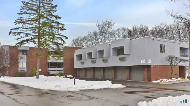 a white building that has a tree in front of it