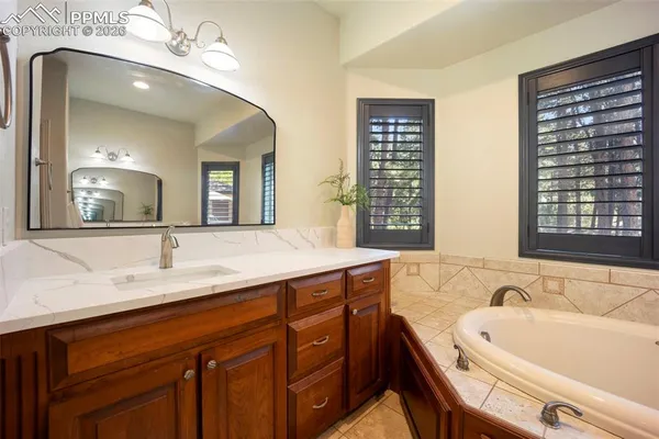 a bath room with a sink and a large mirror