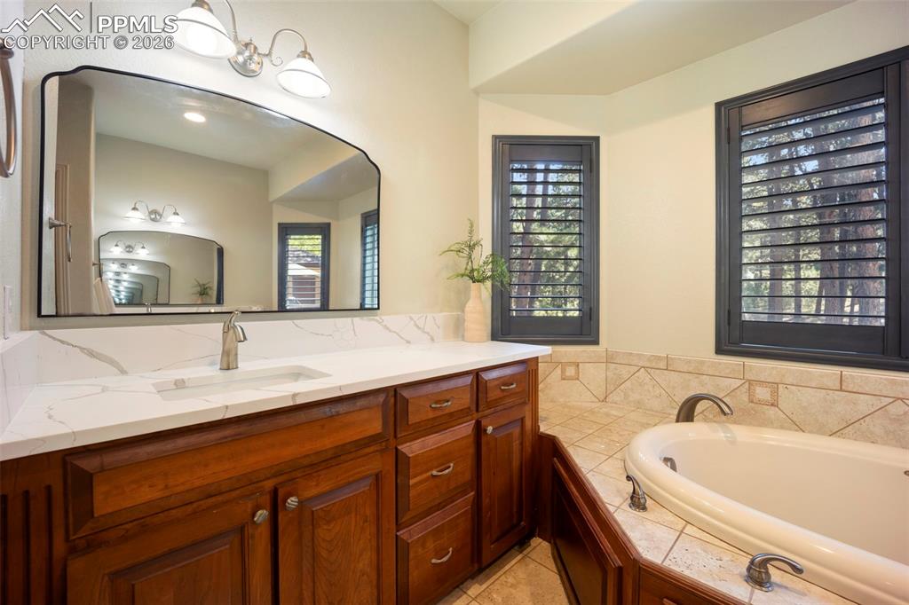 18525 Glenthorne Lane Monument, CO 80132 - Photo 14 of 49 a bath room with a sink and a large mirror