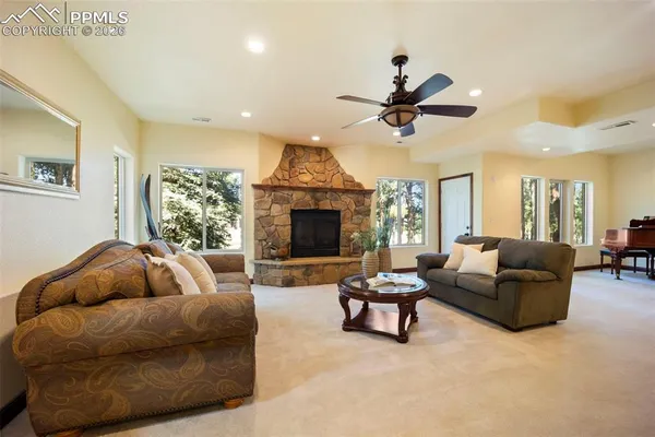 a living room with furniture a ceiling fan and a fireplace