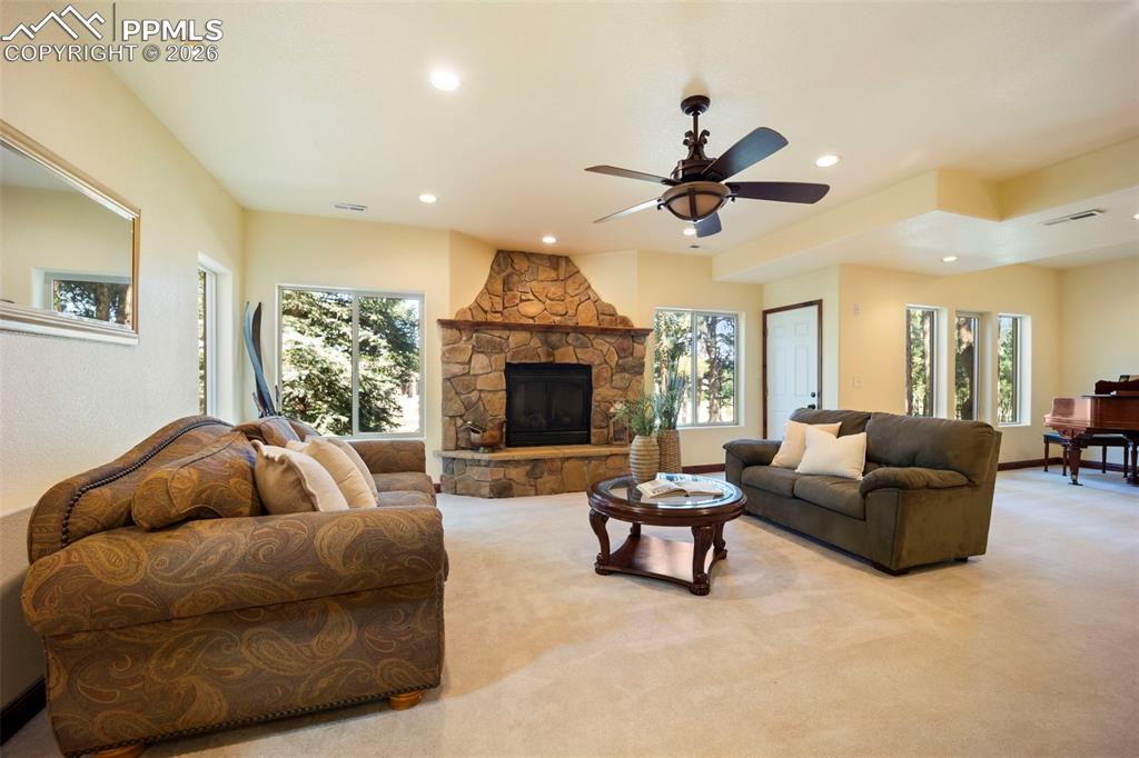 18525 Glenthorne Lane Monument, CO 80132 - Photo 26 of 49 a living room with furniture a ceiling fan and a fireplace