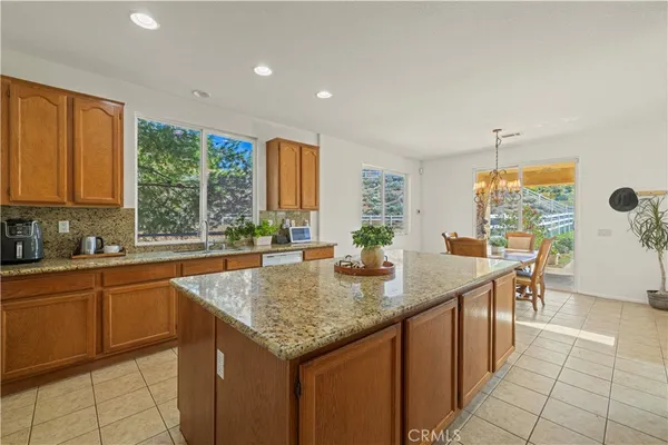 a dining room filled chandelier and kitchen view