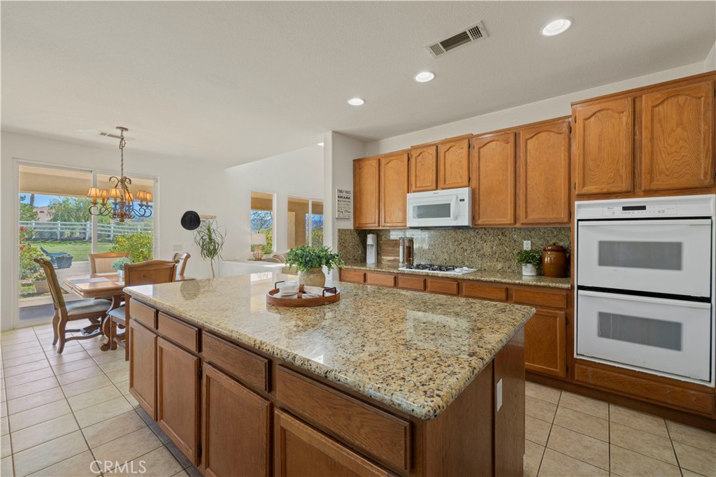 34250 McEnnery Canyon Road Acton, CA 93510 - Photo 8 of 63 a kitchen with kitchen island granite countertop wooden cabinets a stove and a sink