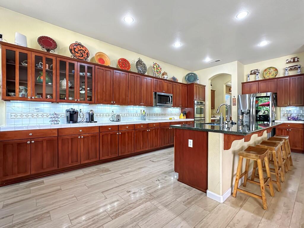 10555 Hampton Creek Drive Reno, NV 89521 - Photo 15 of 50 a kitchen with stainless steel appliances granite countertop wooden cabinets a center island and a sink