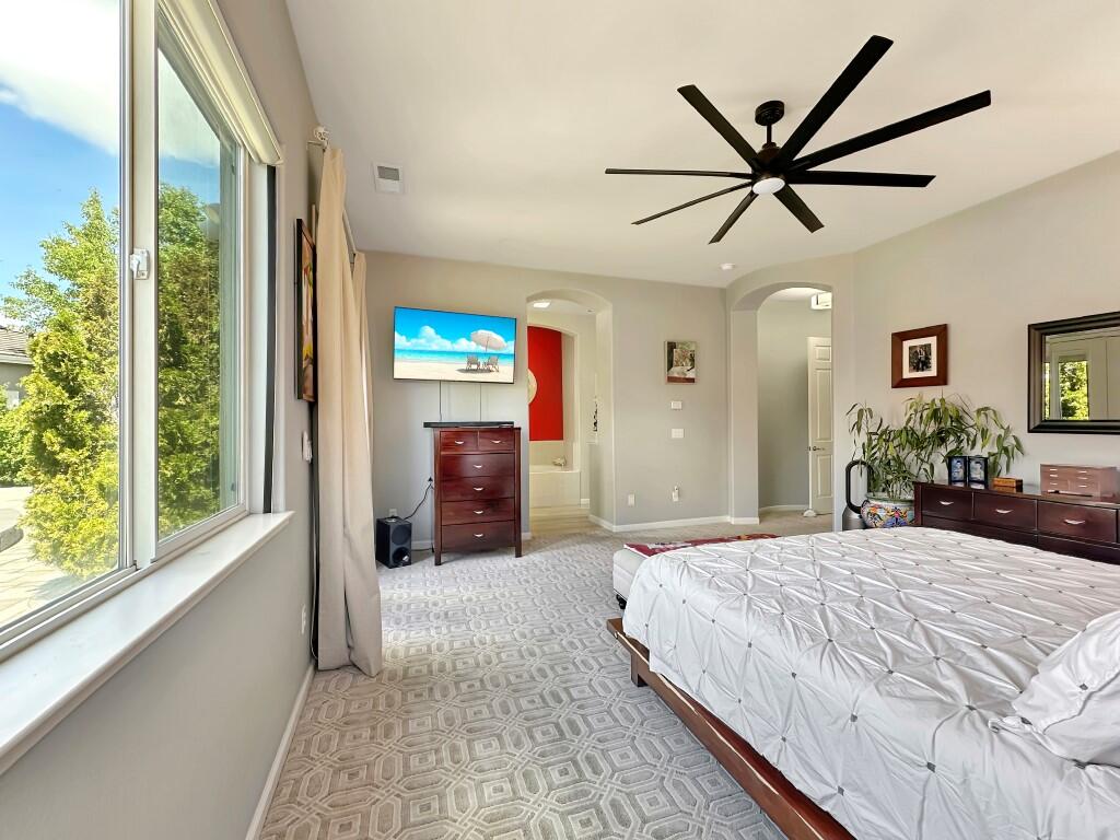 10555 Hampton Creek Drive Reno, NV 89521 - Photo 21 of 50 a bedroom with a large bed and a chandelier