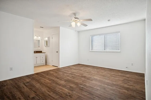a view of a kitchen with wooden floor and a ceiling fan