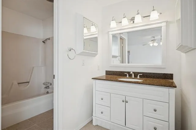a bathroom with a granite countertop sink mirror and