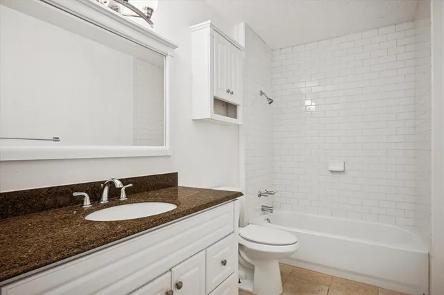 a bathroom with a granite countertop sink toilet a mirror and shower