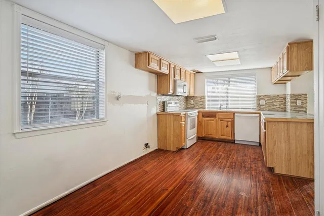 a kitchen with wooden floors and white cabinets