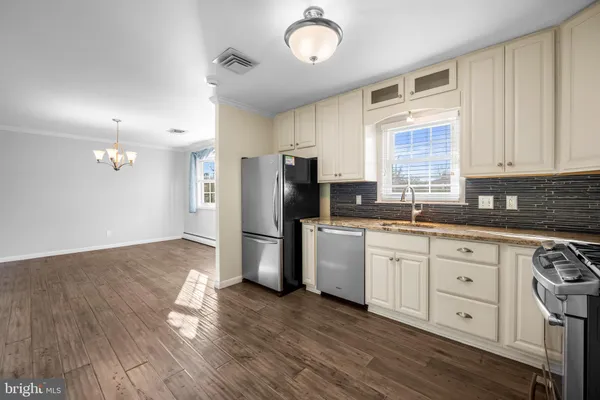 a kitchen with a refrigerator cabinets and wooden floor