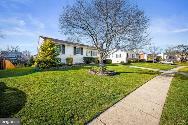 a view of a house with a big yard and large trees