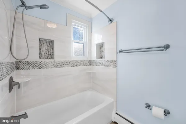 a bathroom with a granite countertop bathtub and shower