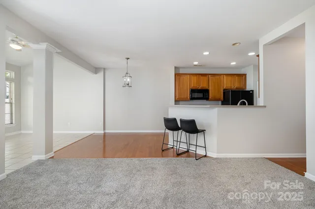 a view of a livingroom with wooden floor and a kitchen space