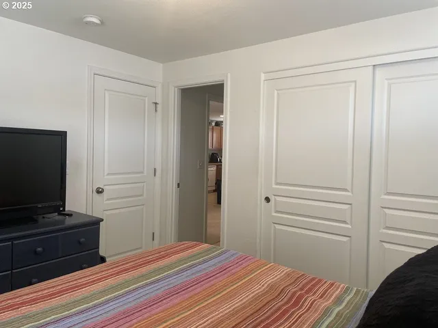 a bedroom with a bed and a flat screen tv