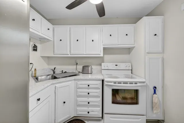 a kitchen with granite countertop a stove sink and cabinets