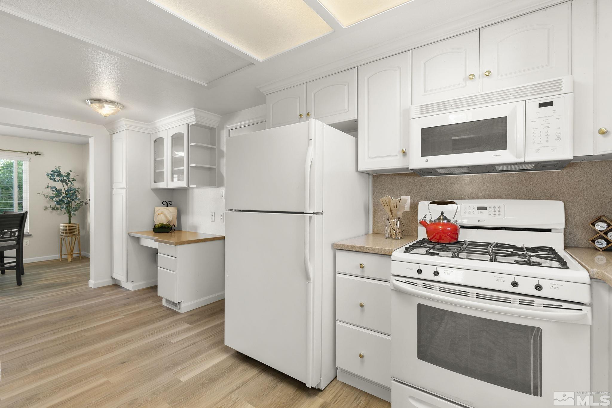 1220 Laredo Court Reno, NV 89503 - Photo 3 of 29 a kitchen with a white stove and white cabinets