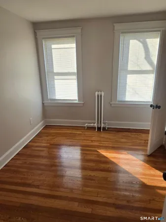 a view of a room with wooden floor and a window