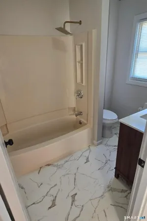 a bathroom with a bathtub and a toilet