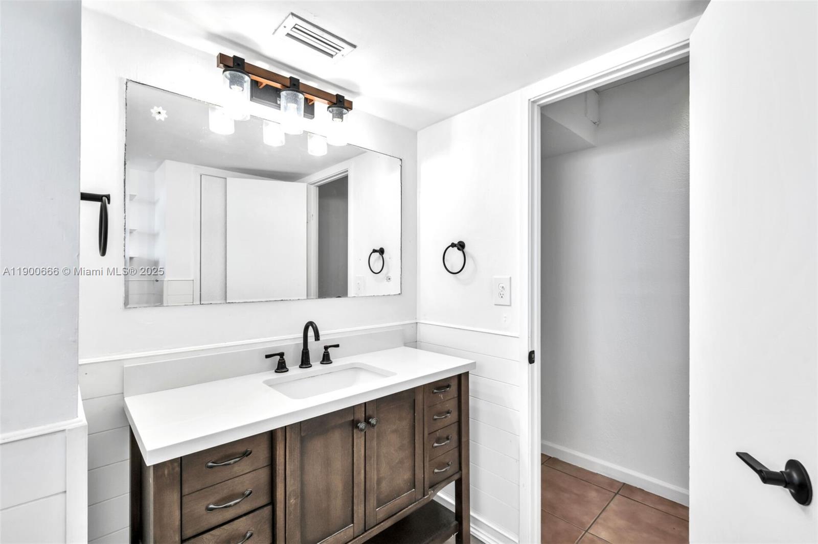1770 Northeast 191st Street, Unit 5081 Miami, FL 33179 - Photo 24 of 35 a bathroom with a sink a mirror and a vanity