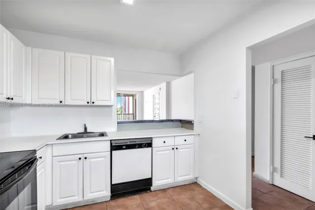 a kitchen with granite countertop white cabinets and white appliances