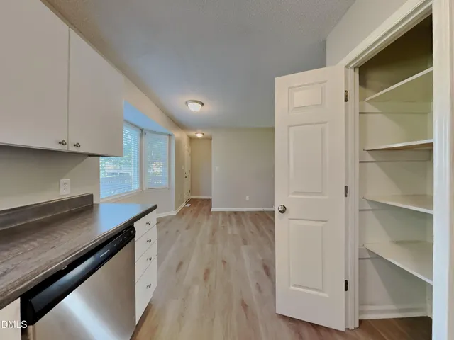 a view of a kitchen with wooden floor and cabinets