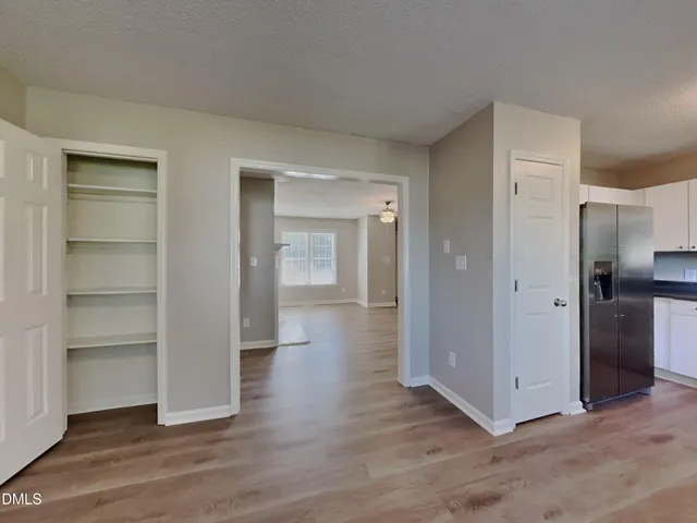 a view of a hallway with wooden floor and closet