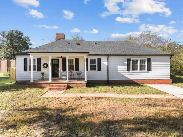 a view of a house with swimming pool and a yard