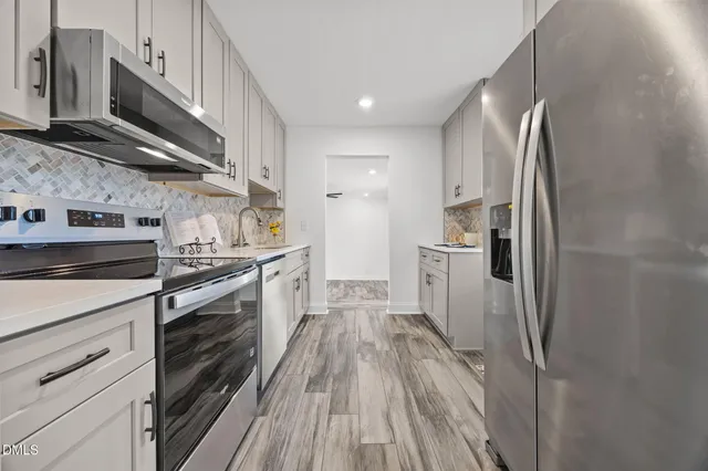 a kitchen with white cabinets and sink
