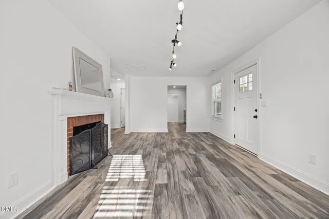 a view of a livingroom with wooden floor and a fireplace