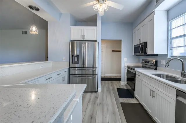 a kitchen with stainless steel appliances a sink dishwasher stove refrigerator and microwave