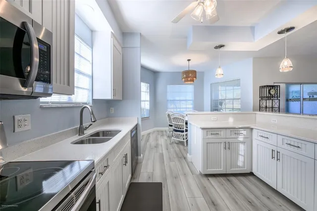 a kitchen with a sink stove cabinets and wooden floor