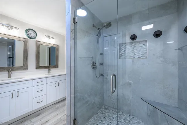 a bathroom with a double vanity sink toilet and shower