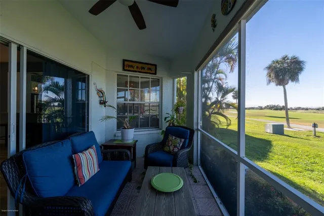 a living room with furniture and a floor to ceiling window next to a large window