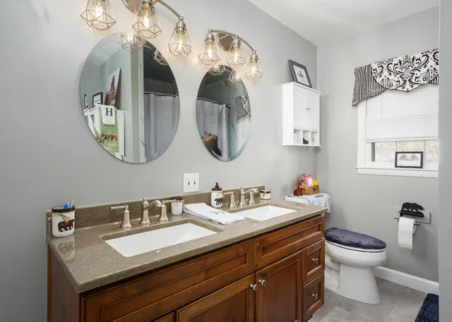 a bathroom with a toilet sink and mirror