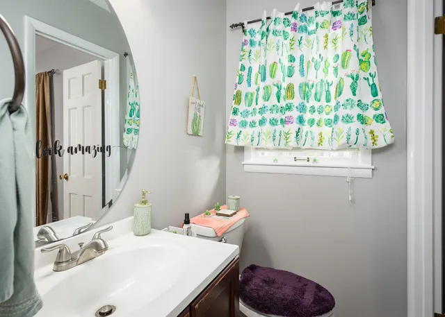 a bathroom with a sink a toilet and a mirror