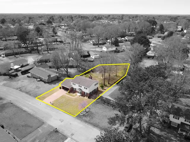 an aerial view of a house with a yard and lake view