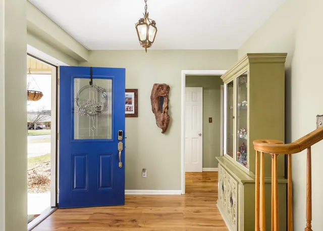 a view of a hallway with wooden floor and windows