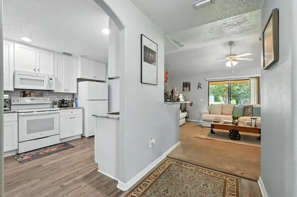 a kitchen with white cabinets and refrigerator